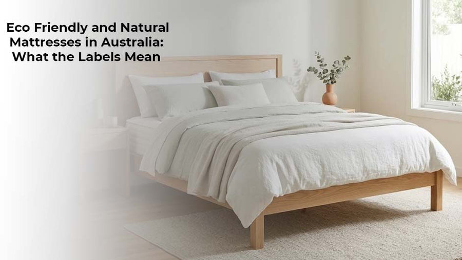 Natural wood bed frame with a white mattress and neutral bedding in a bright, minimalist bedroom, illustrating eco-friendly mattress options.